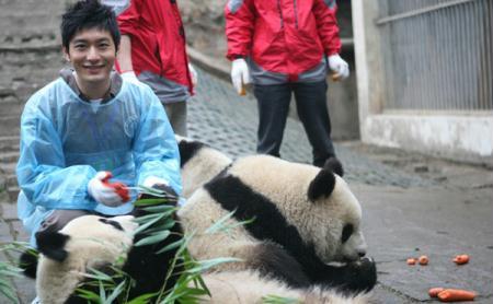 Chinese actor Huang Xiaoming took a break from his filming work on Tuesday to stay with the pandas he has adopted, before their departure for the Shanghai World Expo.