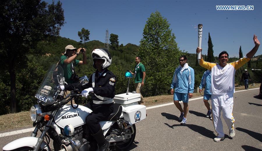 OLYMPIA, April 21, 2016 (Xinhua) -- Second torchbearer, Brazilian volleyball player, Giovane Cavio runs with the Olympic flame during the torch relay in ancient Olympia, Greece, on April 21, 2016, after the lighting ceremony of the Olympic flame in Olympia. (Xinhua/Marios Lolos)