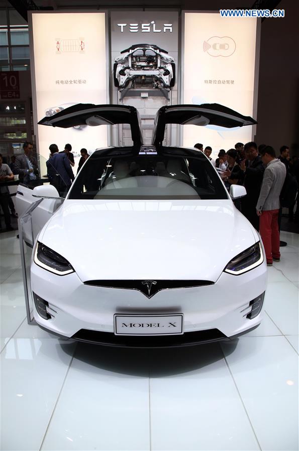 Media reporters watch a Tesla Model X at Beijing International Automotive Exhibition in Beijing, capital of China, April 25, 2016. The exhibition attracted more than 1,600 exhibitors from 14 countries and regions. [Photo: Xinhua/Bai Xuefei]