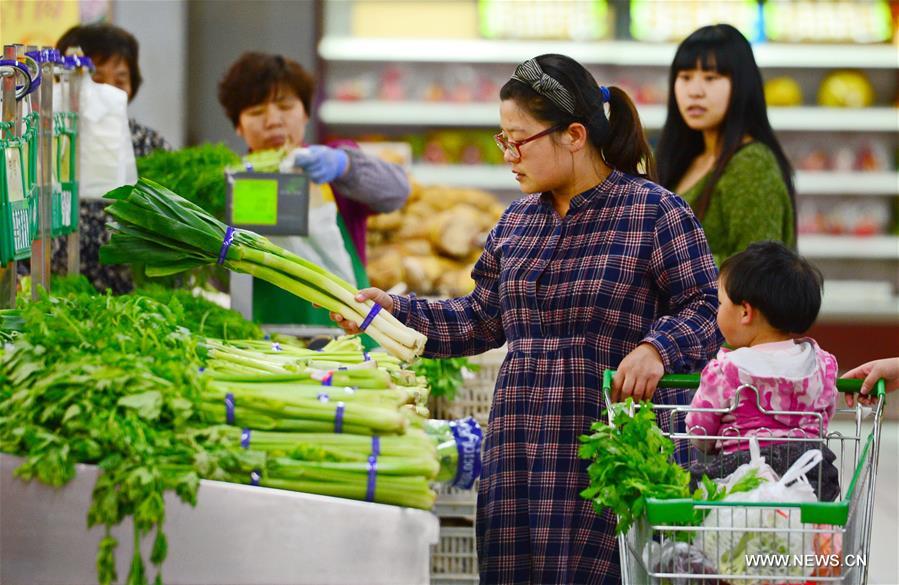 SHIJIAZHUANG, April 11, 2016 (Xinhua) -- A woman chooses vegetables inside a supermarket in Baoding City, north China
