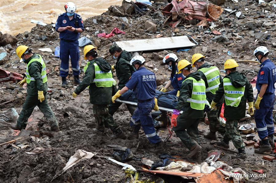 Rescuers carry a body of victim at the landslide site in Taining County, southeast China