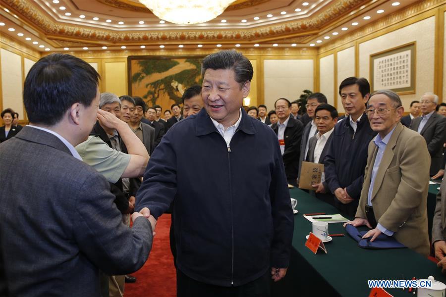 Chinese President Xi Jinping (C front) talks to experts during a symposium discussing the country