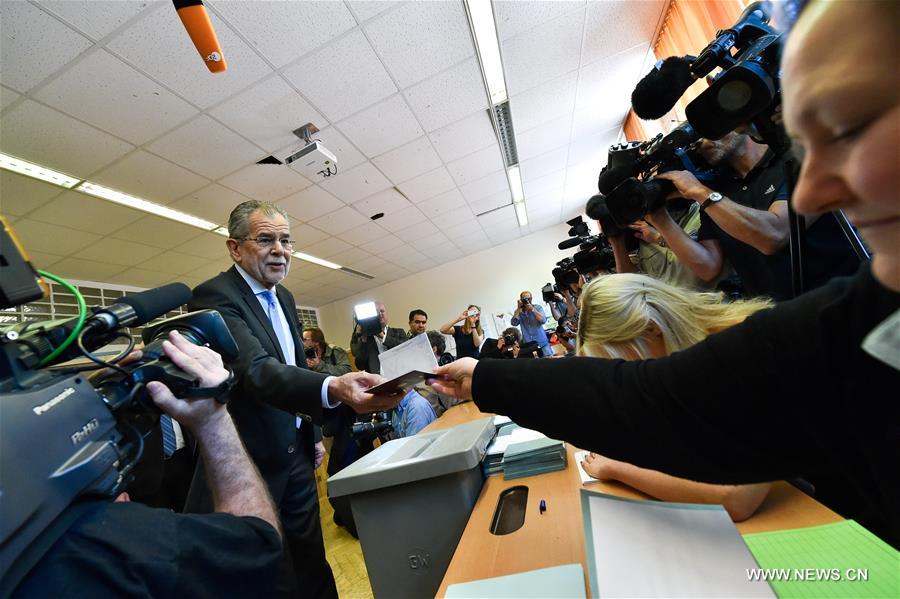 Presidential candidate Alexander Van der Bellen (L) casts his vote at a polling station during the Austrian presidential elections in Vienna, Austria, May 22, 2016. (Xinhua/Qian Yi)