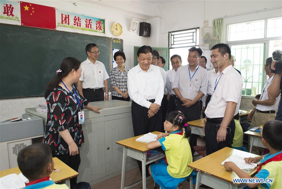 Liu Yunshan, a member of the Standing Committee of the Political Bureau of the Communist Party of China Central Committee, talks with pupils of Jintian Primary School in Jintian Village, Yingde City, south China