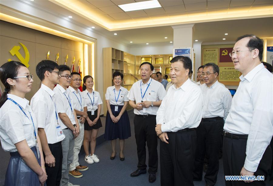 Liu Yunshan, a member of the Standing Committee of the Political Bureau of the Communist Party of China Central Committee, talks with employees as he visits Guoguang Electric Company Ltd. in Guangzhou, capital of south China