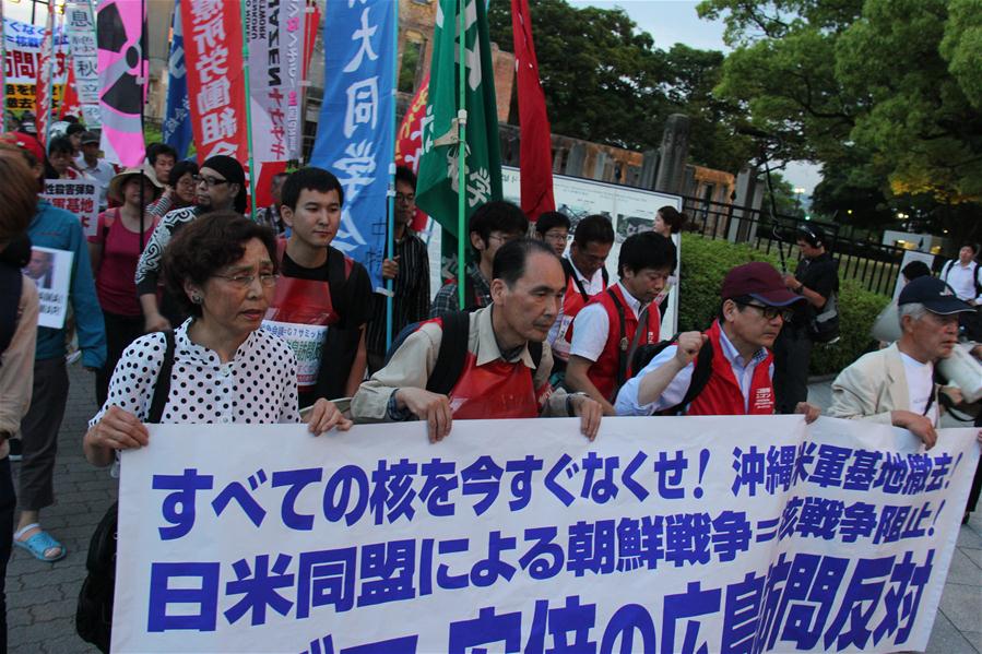 HIROSHIMA, May 26, 2016 (Xinhua) -- People take part in a protest against the visit by U.S. President Barack Obama, near the Hiroshima Peace Memorial Park in Hiroshima, Japan, May 26, 2016. Leaders of the Group of Seven (G7) kicked off a summit in Japan on Thursday, but economic policy divergence among the members and protests in Okinawa against U.S. military are expected to shroud the gathering. Obama is also planned to visit Hiroshima on Friday accompanied by Japanese Prime Minister Shinzo Abe, marking the first sitting U.S. president to visit the city that was obliterated by U.S. atomic bombing at the end of World War II. (Xinhua/Shen Honghui)