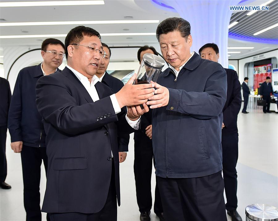 Chinese President Xi Jinping views high-tech products during his visit to the scientific and technological innovation building of Harbin, northeast China