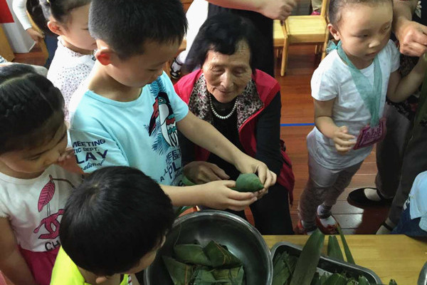 Volunteers make zongzi with community kids.