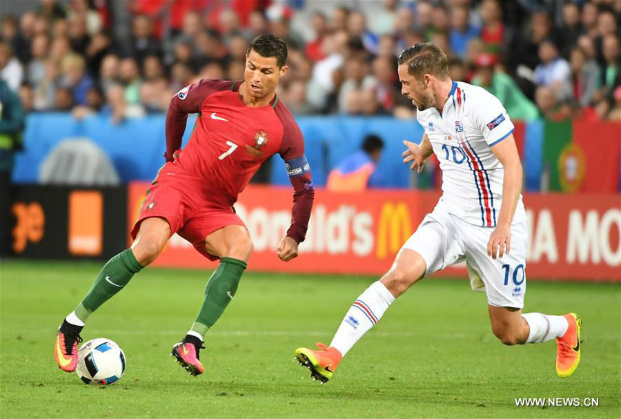 Cristiano Ronaldo (L) of Portugal competes during the Euro 2016 Group F soccer match between Portugal and Iceland in Saint-Etienne, France, June 14, 2016. [Photo: Xinhua]