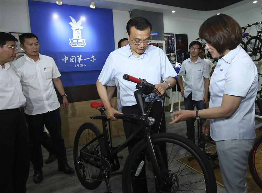 Chinese Premier Li Keqiang (2nd R, front) visits a store of Flying Pigeon bicycle during an inspection tour in Tianjin, north China, June 26, 2016. (Xinhua/Pang Xinglei)