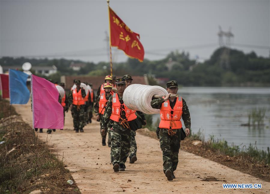 WUHAN, July 13, 2016 (Xinhua) -- Armed police soldiers prepare for the breach of the embankment on the dike of Niushan Lake in central China