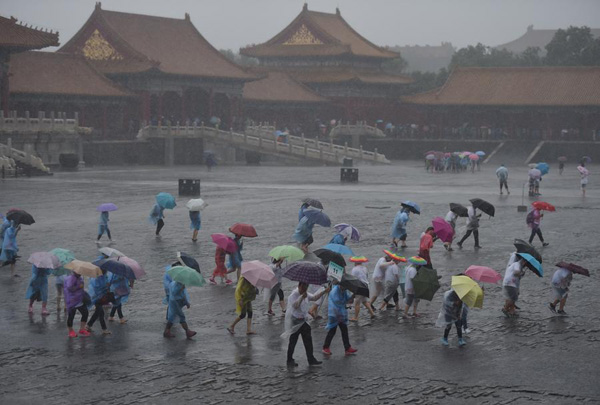 Tourists visit the Forbidden City in rain in Beijing on July 20, 2016. [Photo: Xinhua]