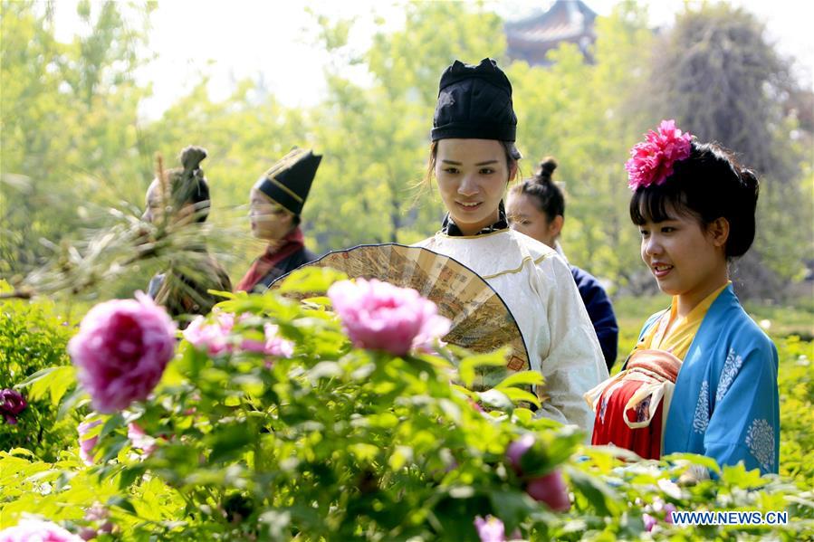 LUOYANG, April 2, 2016 (Xinhua) -- Actors view peony flowers during the Peony Cultural Festival in Luoyang, central China