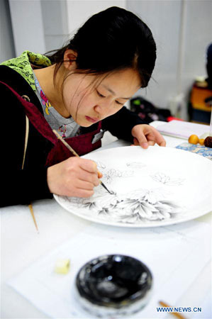 LUOYANG, April 29, 2016 (Xinhua) -- A craftswoman designs peony patterns on a porcelain dish at Luoyang Peony Porcelain Museum in Luoyang, central China