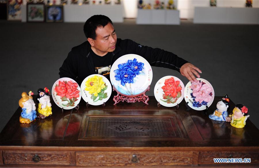 LUOYANG, April 29, 2016 (Xinhua) -- Li Xuewu, a craftsman, shows his porcelain peony handicrafts at Luoyang Peony Porcelain Museum in Luoyang, central China