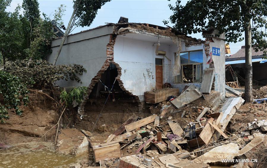  Rescuers clean up a village road after floods in Daxian Village of Xingtai City, north China