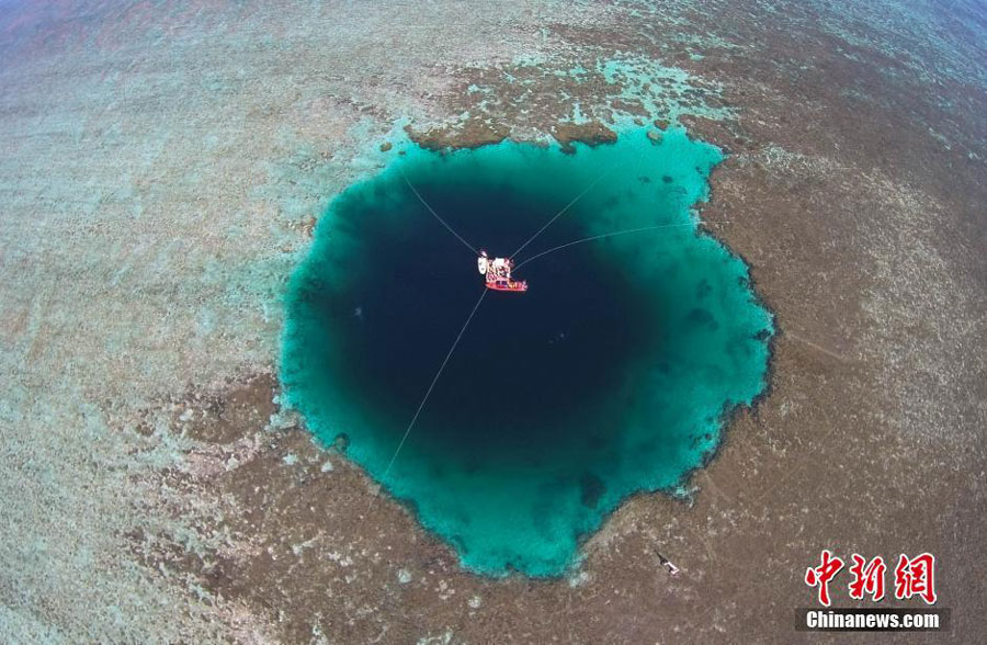 An aerial photo taken on July 24, 2016 shows the "Sansha Yongle Blue Hole", which was officially named by the Sansha municipal government on Sunday, in Yongle, a major coral reef in the Xisha Islands. It was confirmed on Friday by Chinese researchers that it is the world