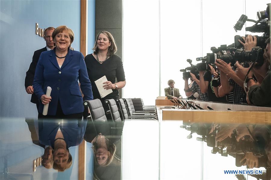 German Chancellor Angela Merkel (L, front) leaves after a press conference in Berlin, Germany, on July 28. 2016. German Chancellor Angela Merkel repeated her immigration mantra "We can do it" on Thursday after recent string of attacks shocked the country, while raising a nine-point plan to ensure security, which includes increasing security personnel, establishing an information center, and enhancing international cooperation. (Xinhua/Zhang Fan) 