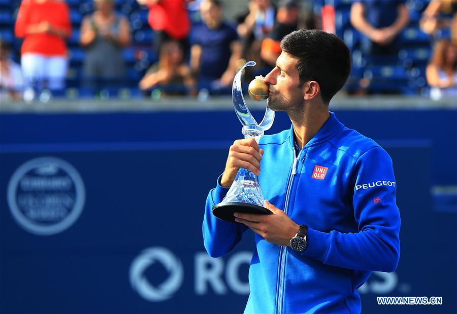 Novak Djokovic of Serbia kisses his trophy during the awarding ceremony of the men