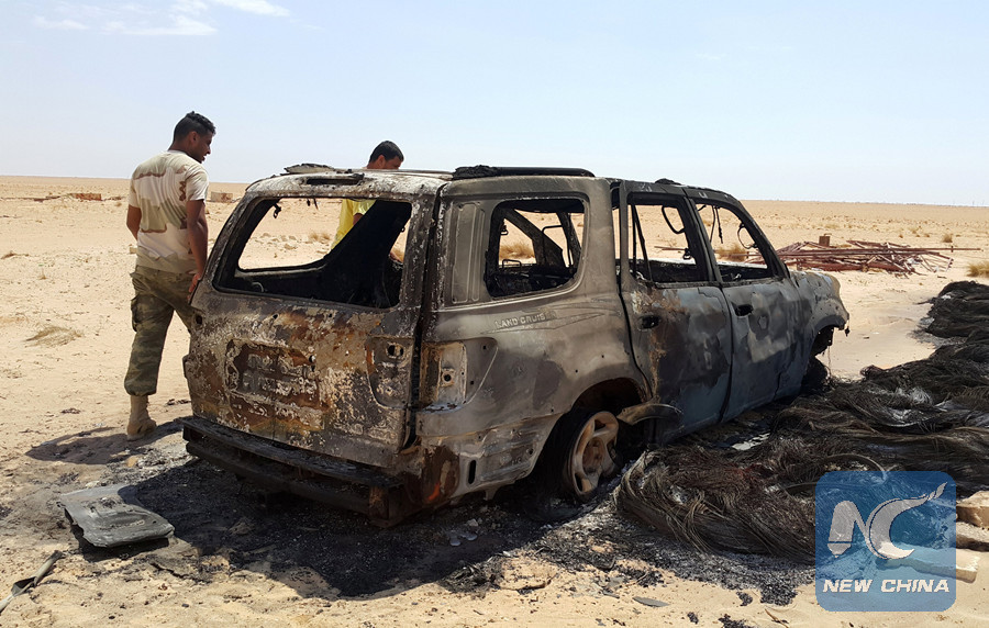 Men inspect the wreckage of a vehicle following clashes between forces loyal to eastern Libyan commander Khalifa Haftar andBenghazi Defence Brigades (BDB), an Islamist-leaning armed group, in the Magrun area, south of Benghazi, Libya July 21, 2016. (Reuters photo) 