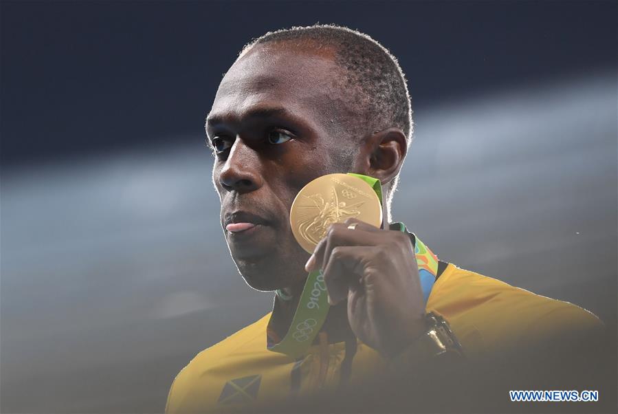 Usain Bolt of Jamaica shows the gold medal at the awarding ceremony of men