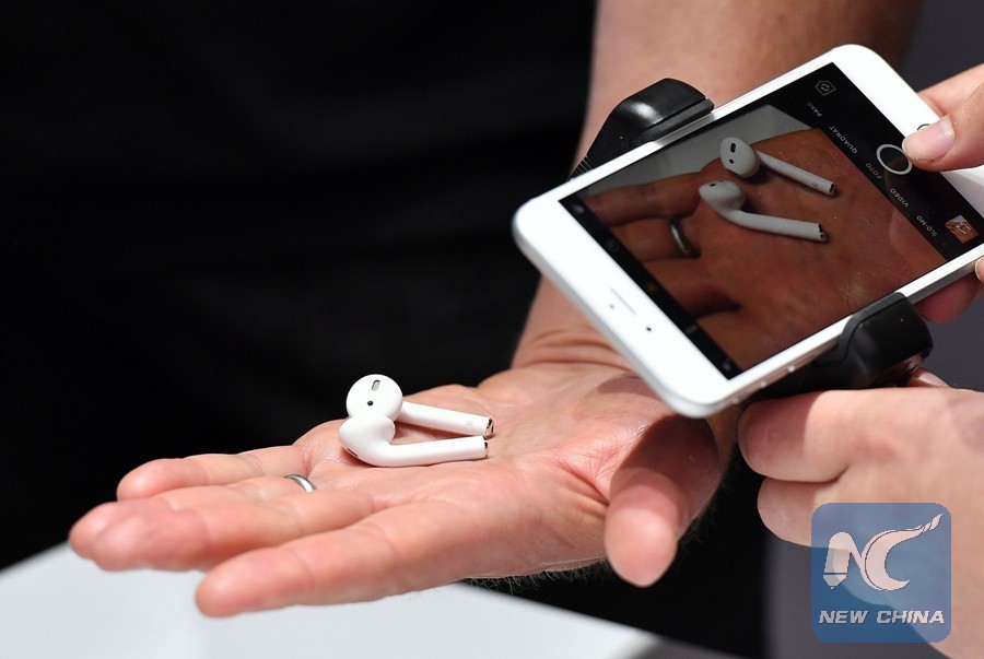 A person takes a photo of a set of wireless Apple AirPods during a media event at Bill Graham Civic Auditorium in San Francisco, California on September 07, 2016. (Xinhua/ AFP PHOTO)