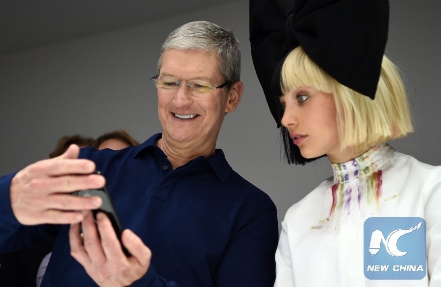 Apple CEO Tim Cook (L) shows dancer Maddie Ziegler (R) a newiPhone during a product demonstration at Bill Graham Civic Auditorium in San Francisco, California on September 07, 2016. (Xinhua/AFP PHOTO)