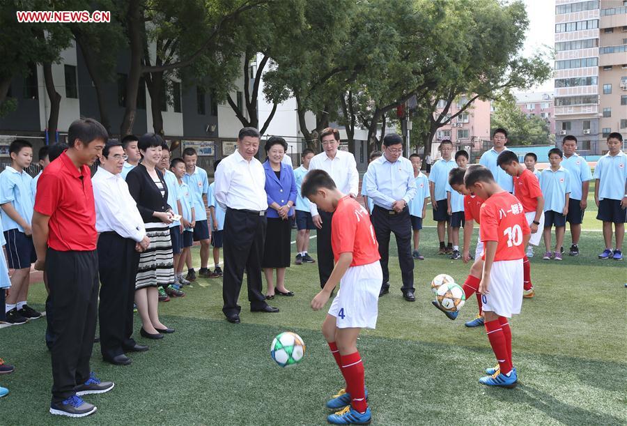 Chinese President Xi Jinping watches a football training session during an inspection visit to Beijing Bayi School before the upcoming national Teacher