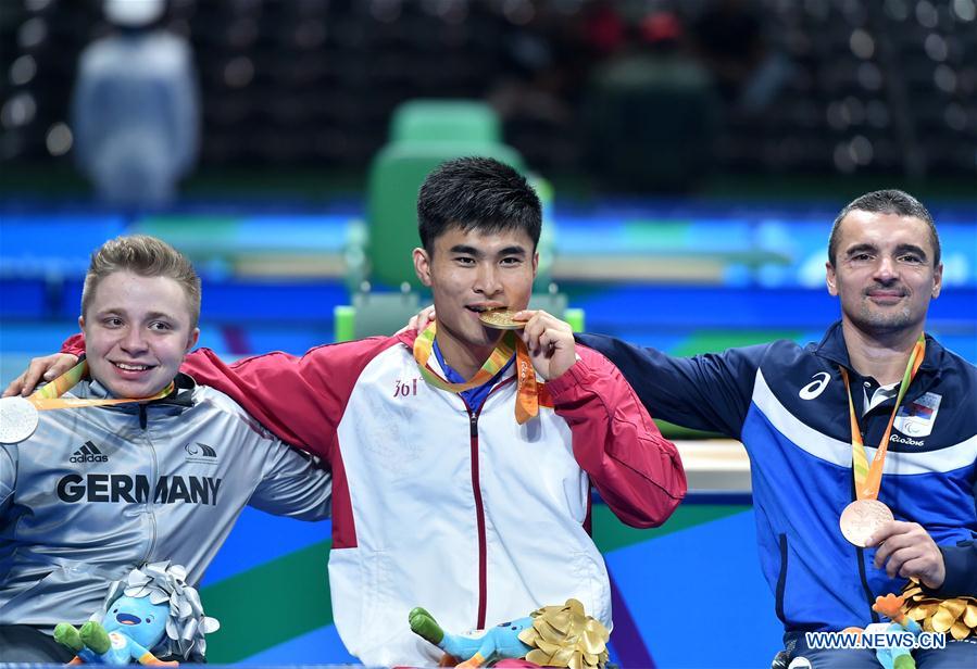 Cao Ningning (C) of China reacts during the medal presenting ceremony after Men