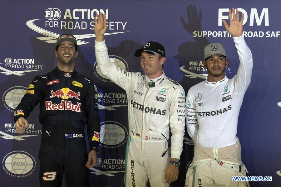 Mercedes driver Nico Rosberg (C) of Germany celebrates his pole position as he stands next to Red Bull driver Daniel Ricciardo (L) of Australia and Mercedes driver Lewis Hamilton of Britain after the qualifying session on Day 2 of 2016 Singapore F1 Grand Prix Night Race, Sept. 17, 2016. (Xinhua/Then Chih Wey)