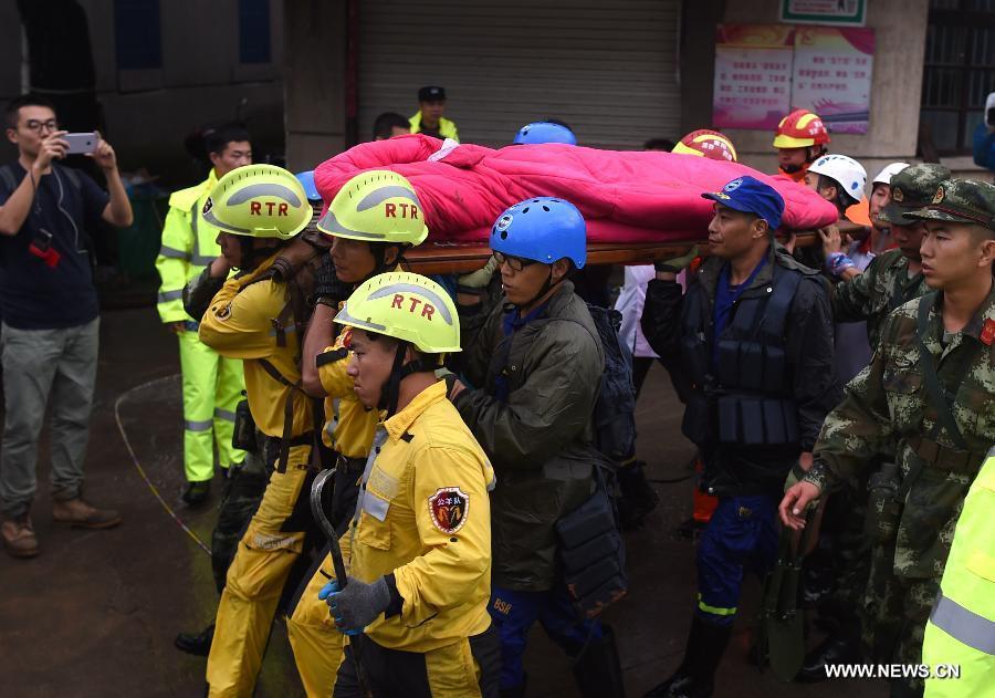 Rescuers carry the body of a victim after a landslide hit Suichang County, east China