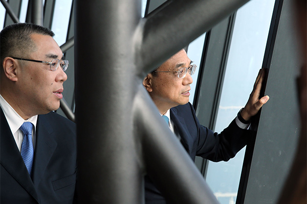 Premier Li Keqiang, right, climbs to the top of Macao Tower on Oct 10 accompanied by Macao’s Chief Executive Chui Sai On, left. [Photo/provided to chinadaily.com.cn]
