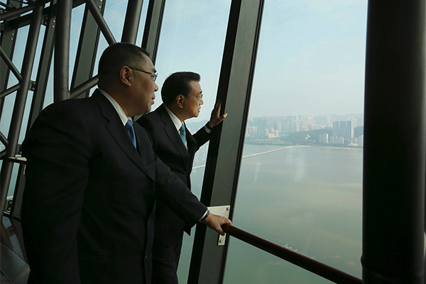 Premier Li Keqiang, right, climbs to the top of Macao Tower on Oct 10 accompanied by Macao’s Chief Executive Chui Sai On, left. [Photo/provided to chinadaily.com.cn]