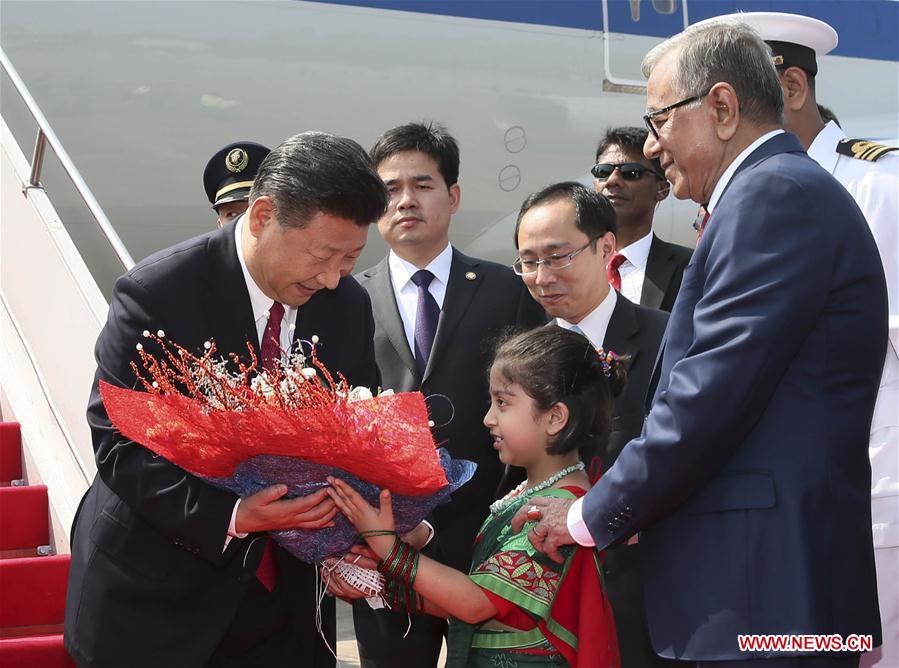 Chinese President Xi Jinping (1st L) accepts a bouquet upon his arrival at the airport in Dhaka, Bangladesh, Oct. 14, 2016. Xi Jinping arrived here Friday for a state visit. (Xinhua/Lan Hongguang)