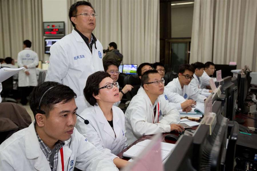 Staff members work before the Shenzhou-11 manned spacecraft