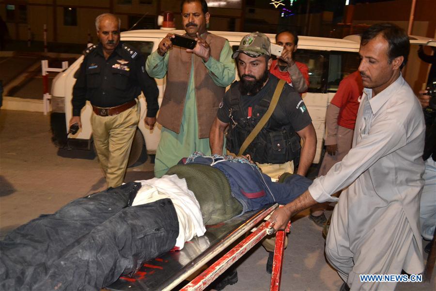 People transfer an injured police trainee to a hospital in southwest Pakistan