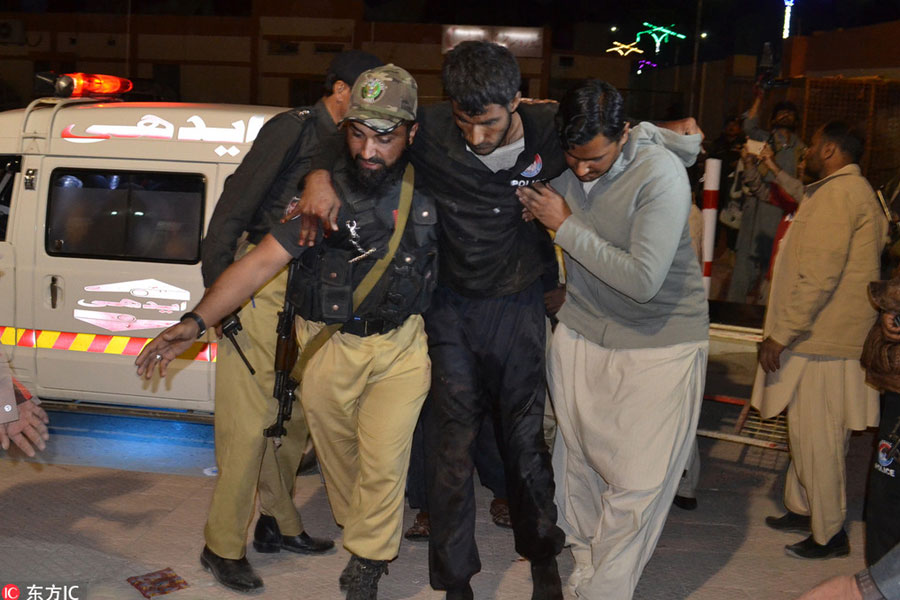 A Pakistani volunteer and a police officer rush an injured person to a hospital in Quetta, Pakistan, Oct 24, 2016. [Photo/IC]