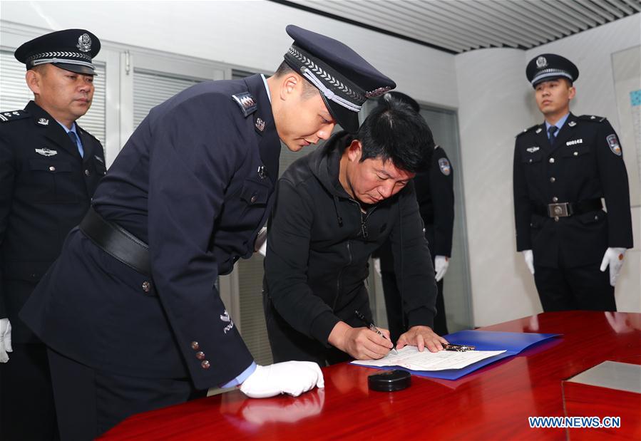 Yan Yongming, a graft fugitive who had been on the run for 15 years, signs on his arrest warrant after returning to China to turn himself in at Capital International Airport in Beijing, capital of China, Nov. 12, 2016. Yan Yongming, 47, who was the former chairman of the pharmaceutical company Tonghua Golden-horse in northeast China