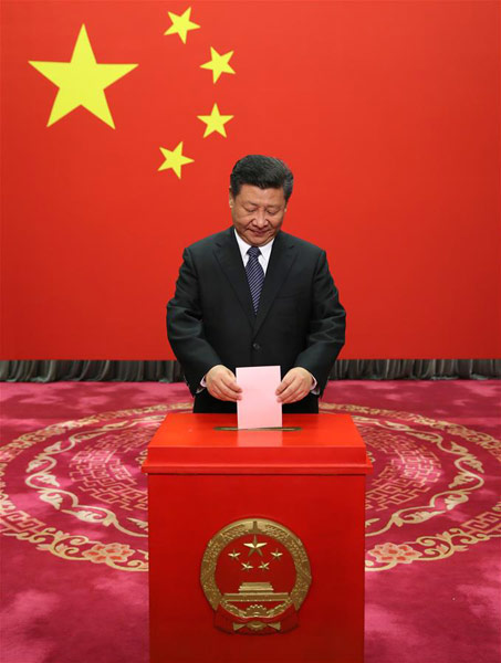 Chinese President Xi Jinping casts his ballot at a voting booth to elect new deputies for the local people