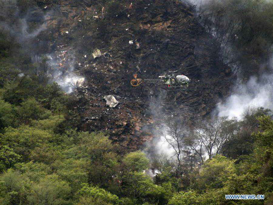 Photo taken on Dec. 7, 2016, shows a helicopter flying over the site of a plane crash in northwest Pakistan