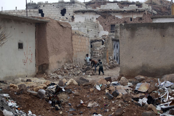 Children play near rubble of damaged buildings in al-Rai town, northern Aleppo countryside, Syria December 25, 2016. [Photo/Agencies]