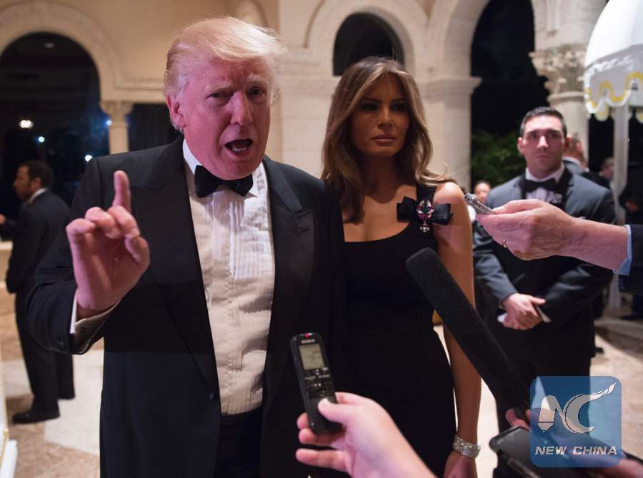 US President-elect DonaldTrumpanswers questions from reporters accompanied by wife Melania for a New Year