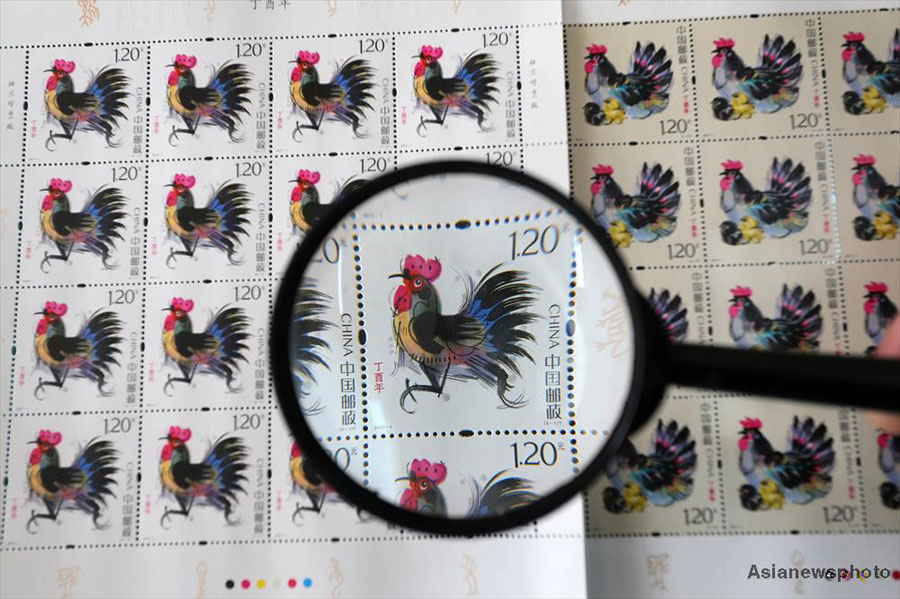 Rooster-themed stamps to celebrate the Year of the Rooster are displayed at a post office in Weifang, Shandong province, on Tuesday. [Photo: Asianewsphoto]
