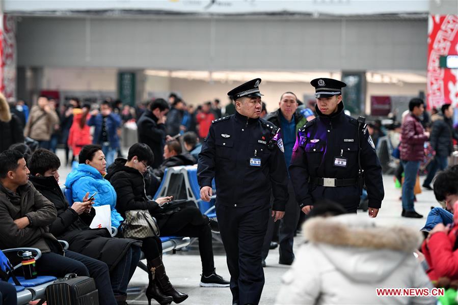Police officers Gao Yang (C-L) and Nie Yingjie (C-R) patrol at the Changchun Railway Station during Spring Festial travel rush in northeast China