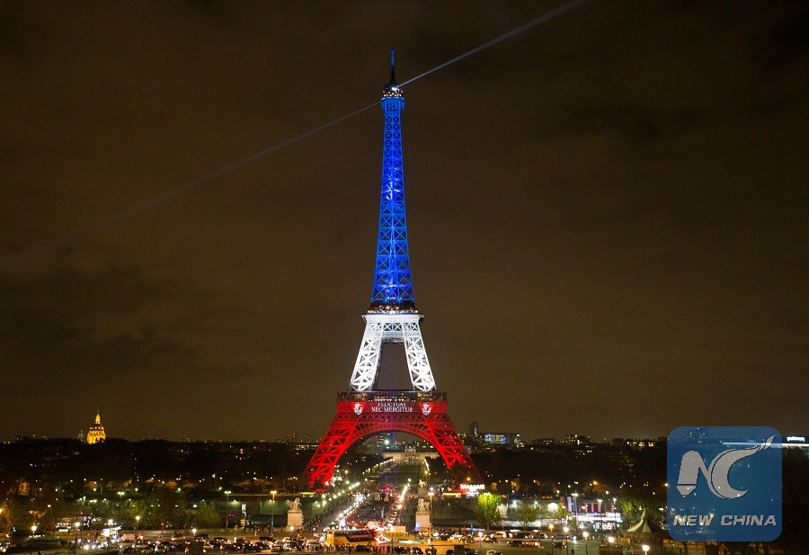 The Eiffel Tower is lit with the blue, white and red colours of the French flag in Paris, France, Nov. 16, 2015, to pay tribute to the victims of the terror attacks on Friday in the French capital. (Xinhua/Xu Jinquan)