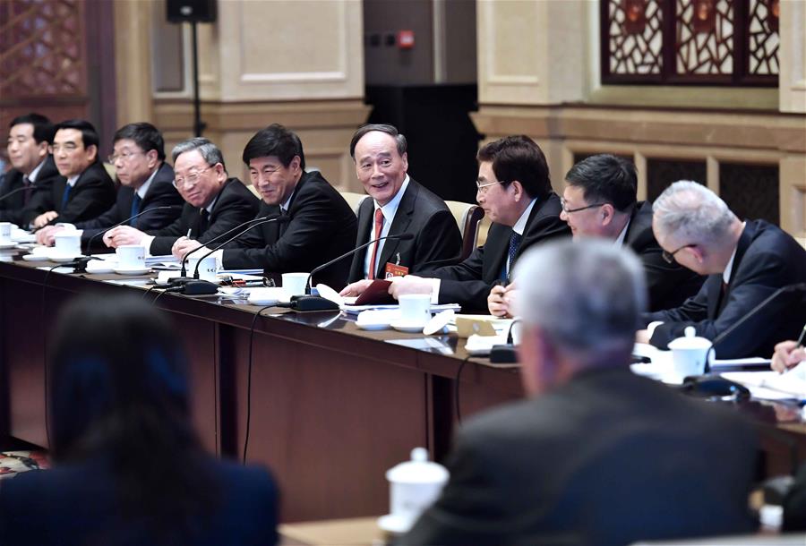 Wang Qishan, a member of the Standing Committee of the Political Bureau of the Communist Party of China (CPC) Central Committee, joins a panel discussion with deputies to the 12th National People