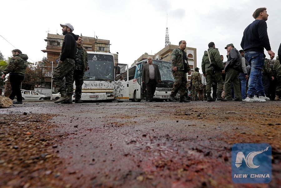 Syrian security forces and locals gather at the scene of a twin bombing targeting Shiite pilgrims in Damascus