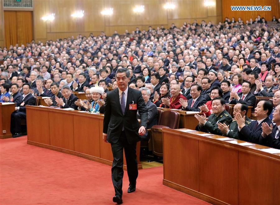 Leung Chun-ying walks to the rostrum after being elected vice chairman of the 12th National Committee of the Chinese People