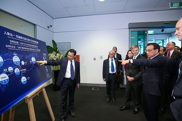 Premier Li Keqiang was accompanied by his New Zealand counterpart, Bill English, on a visit to the research center of Fisher & Paykel, a well-known local household appliance company, now majority-owned by Haier Group, a Chinese firm, in Auckland, a city in the North Island of New Zealand, on March 28.