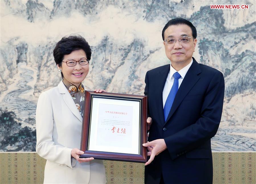 Chinese Premier Li Keqiang (R) grants the official certificate of appointment to Lam Cheng Yuet-ngor as the fifth-term chief executive of Hong Kong Special Administrative Region in Beijing, capital of China, April 11, 2017. (Xinhua/Yao Dawei)